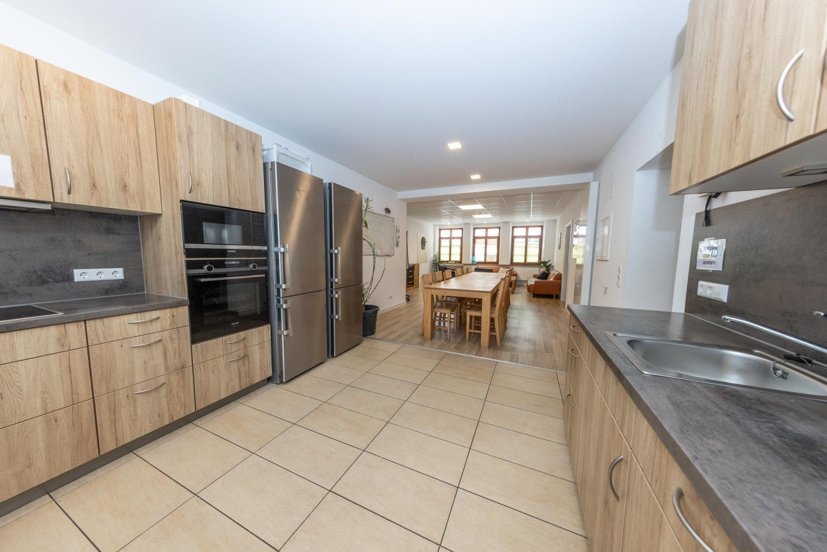Moderne K&uuml;che mit Holzschr&auml;nken und Fliesenb&ouml;den.