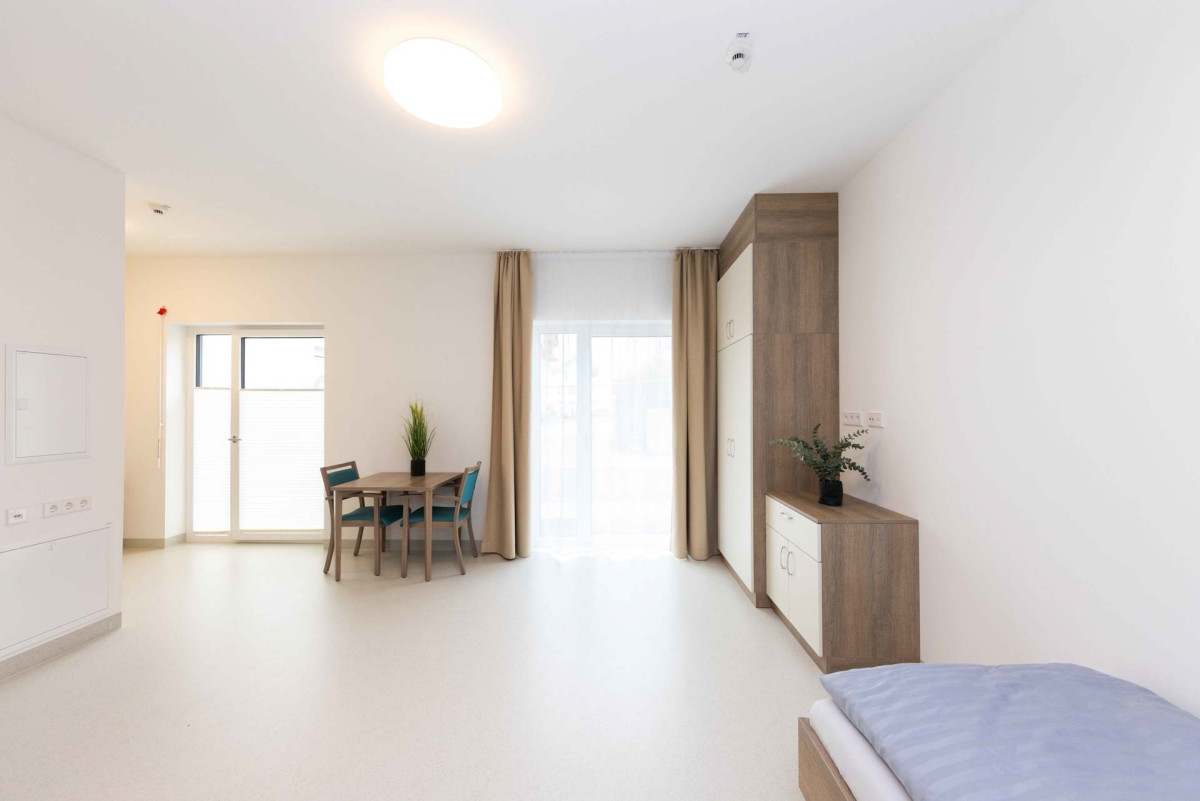 Helles Wohnzimmer mit Essbereich und Schlafplatz.