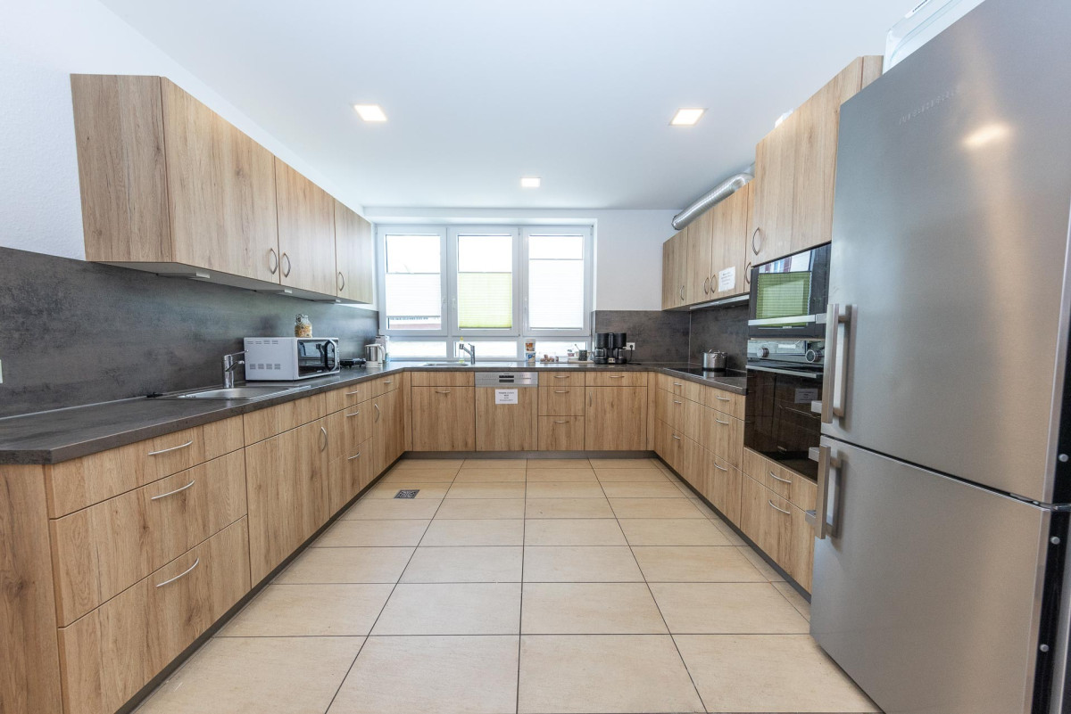 Moderne K&uuml;che mit Holzschr&auml;nken und Edelstahlger&auml;ten.