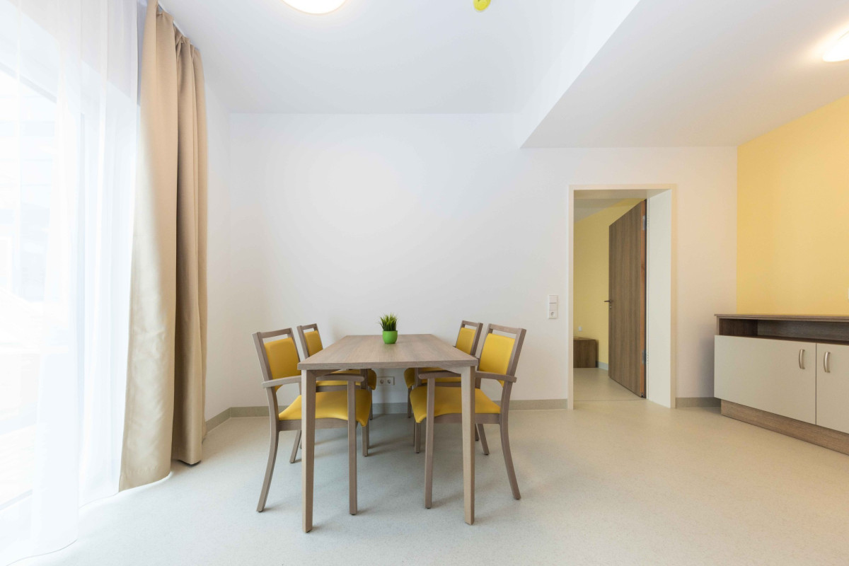 Modernes Wohnzimmer mit Esstisch und vier St&uuml;hlen.