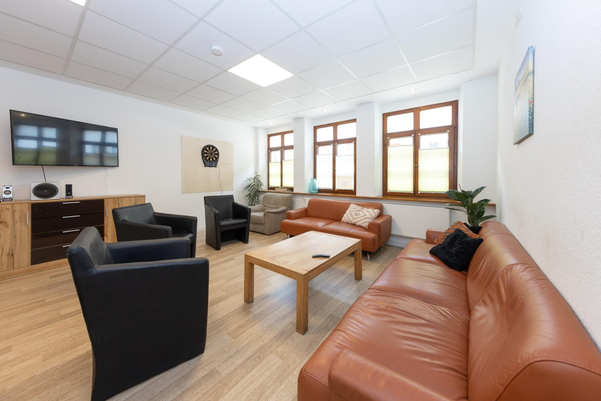 Helles Wohnzimmer mit Sofas und Sesseln.