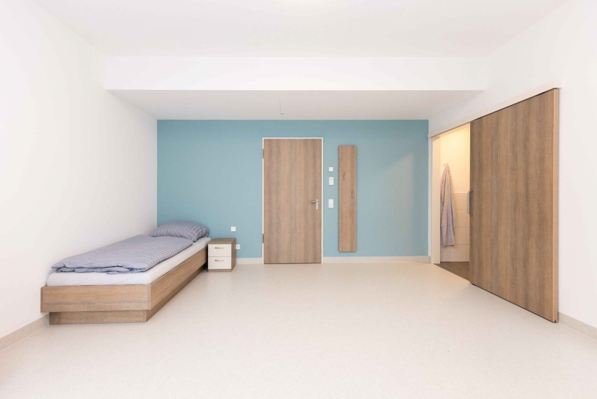 Modernes Zimmer mit Bett und Holzm&ouml;beln.