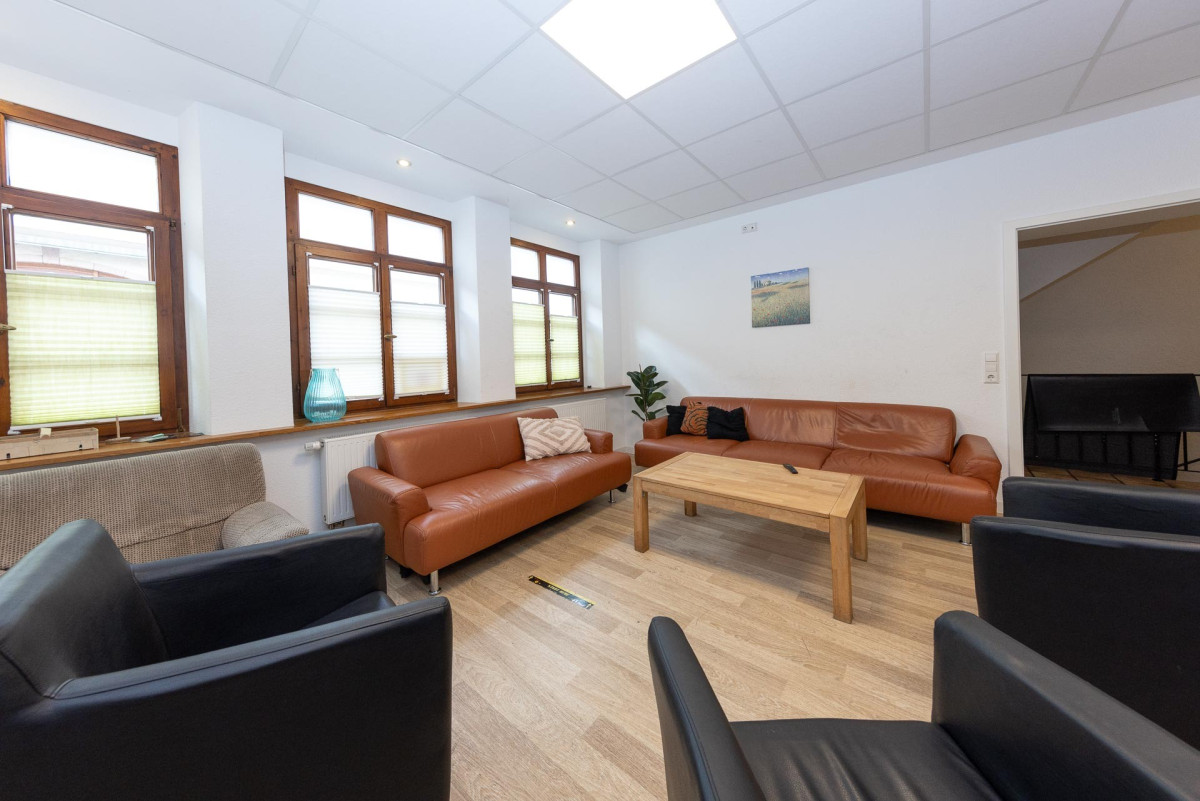 Helles Wohnzimmer mit Sofas und Holztisch.