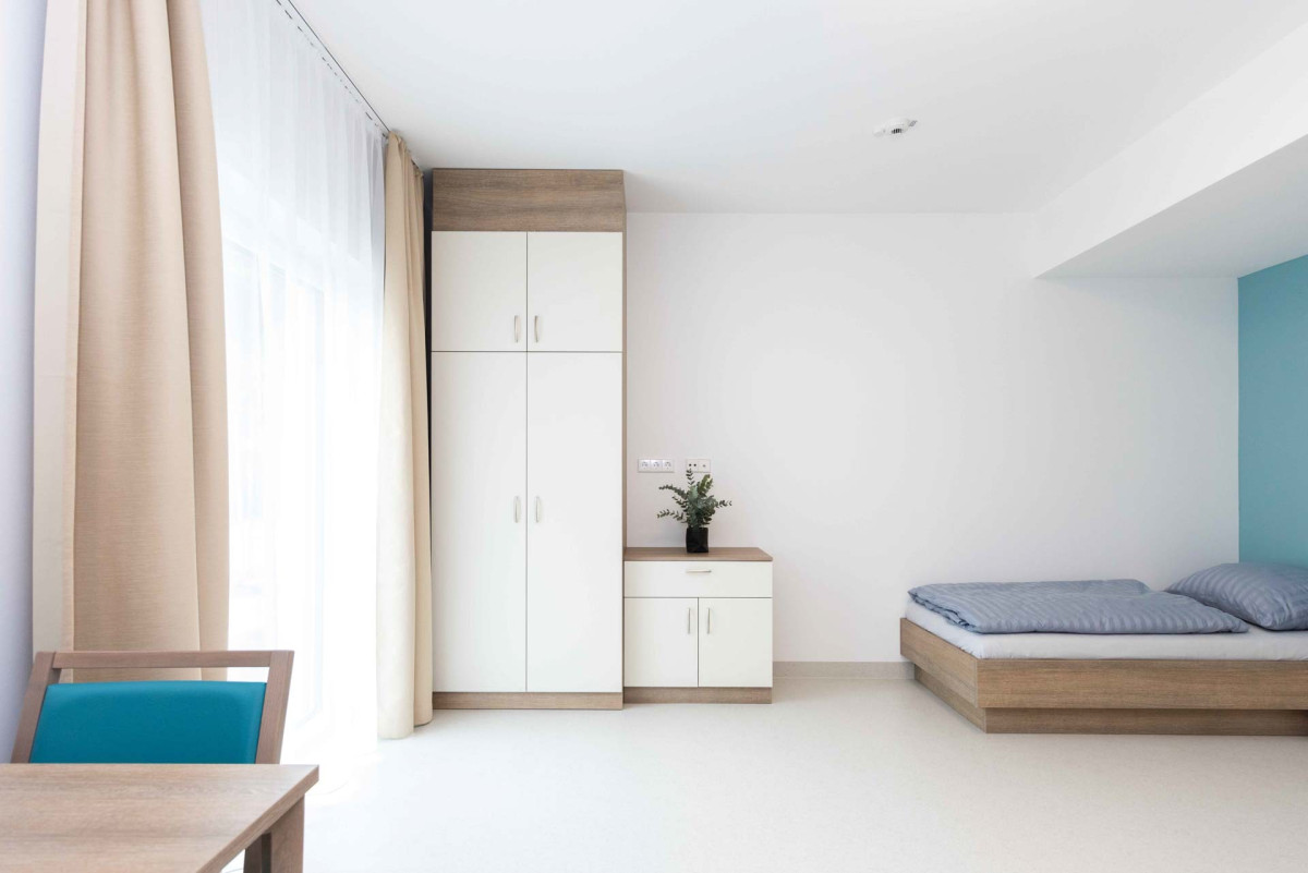 Minimalistisches Schlafzimmer mit Holzbett und wei&szlig;en Schr&auml;nken.