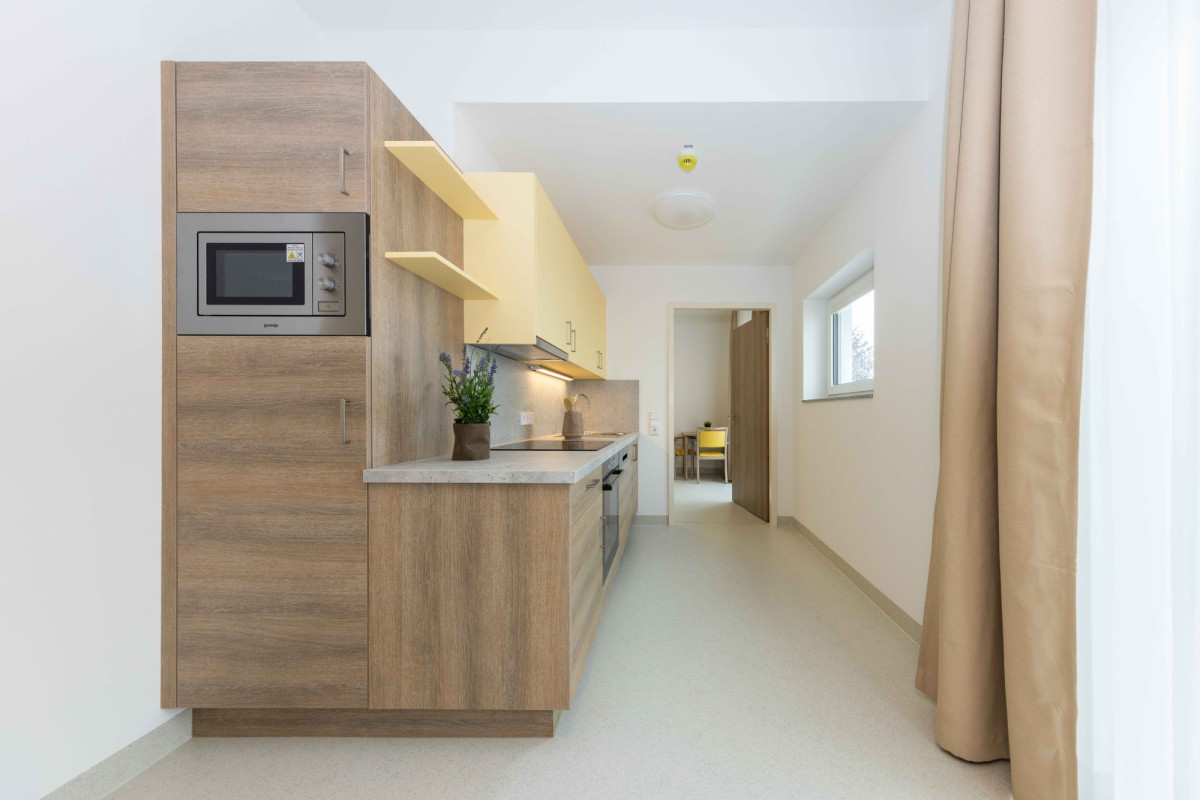 Moderne K&uuml;che mit Holzfronten und gelben Regalen.