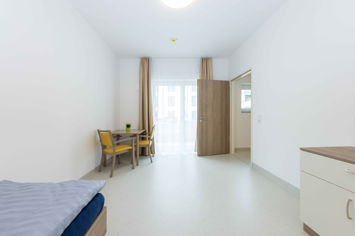 Helles Zimmer mit Bett, Schreibtisch und Eingangst&uuml;r.