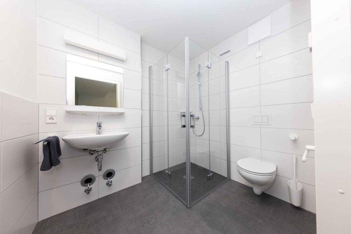 Modernes barrierefreies Badezimmer mit Dusche.