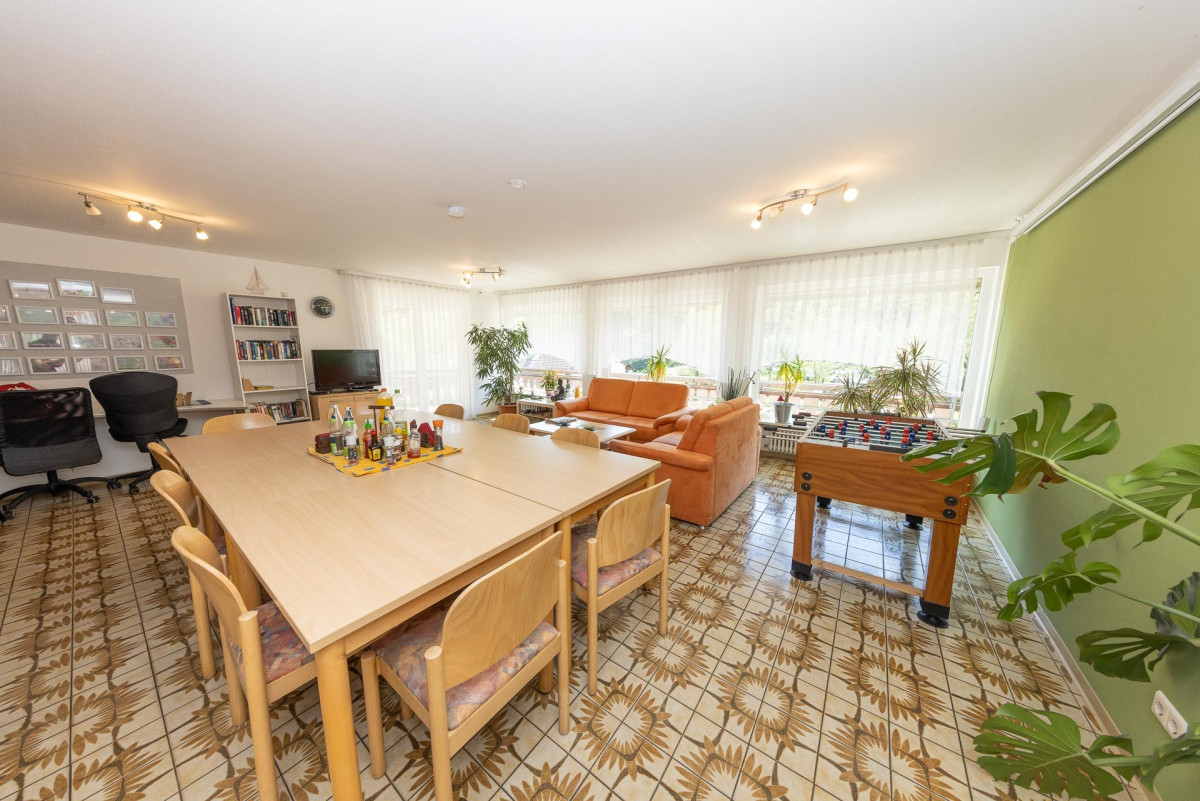 Helles Wohnzimmer mit Esstisch und M&ouml;beln.