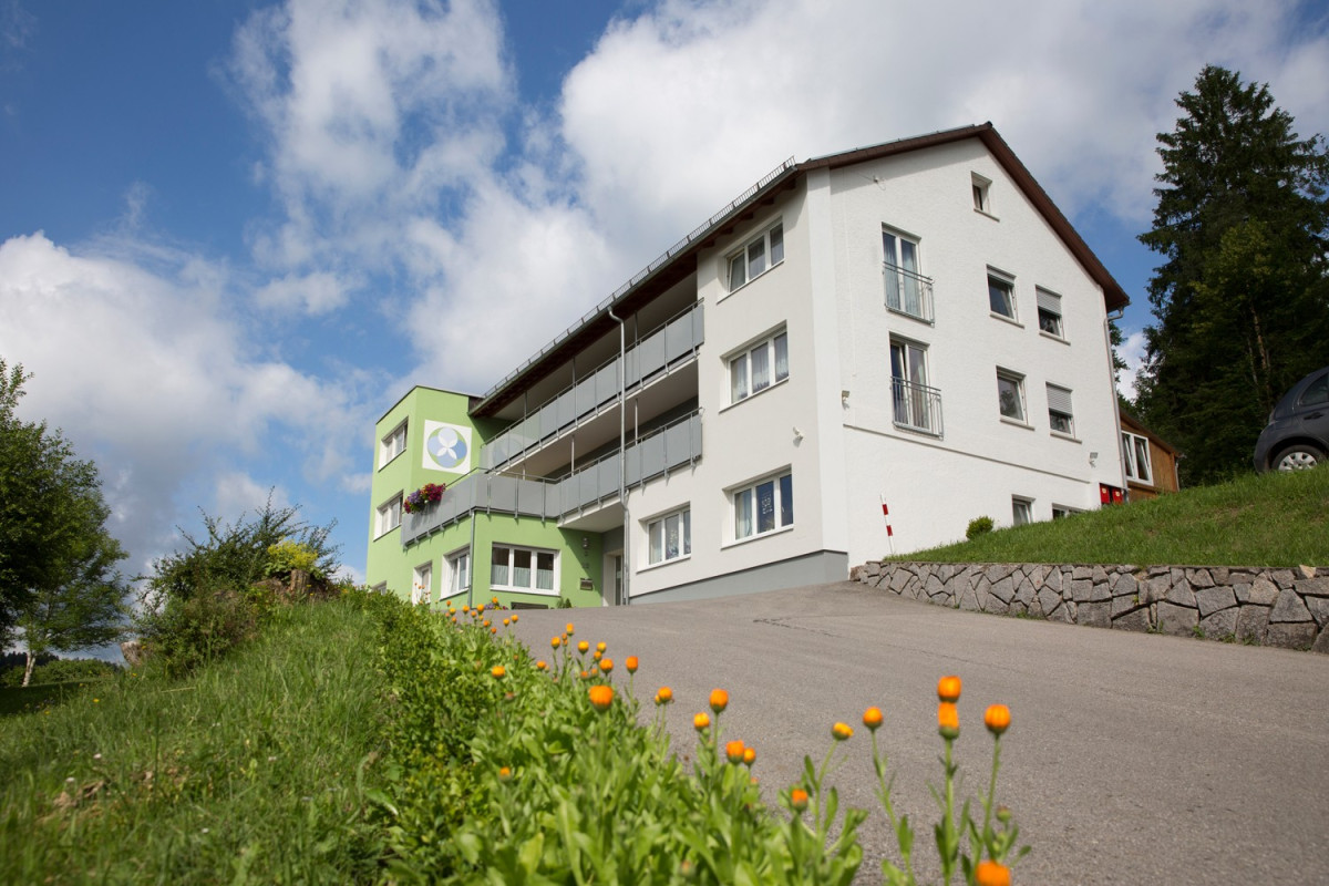 Haus Berghof, modernes Wohngeb&auml;ude mit gr&uuml;ner Fassade.