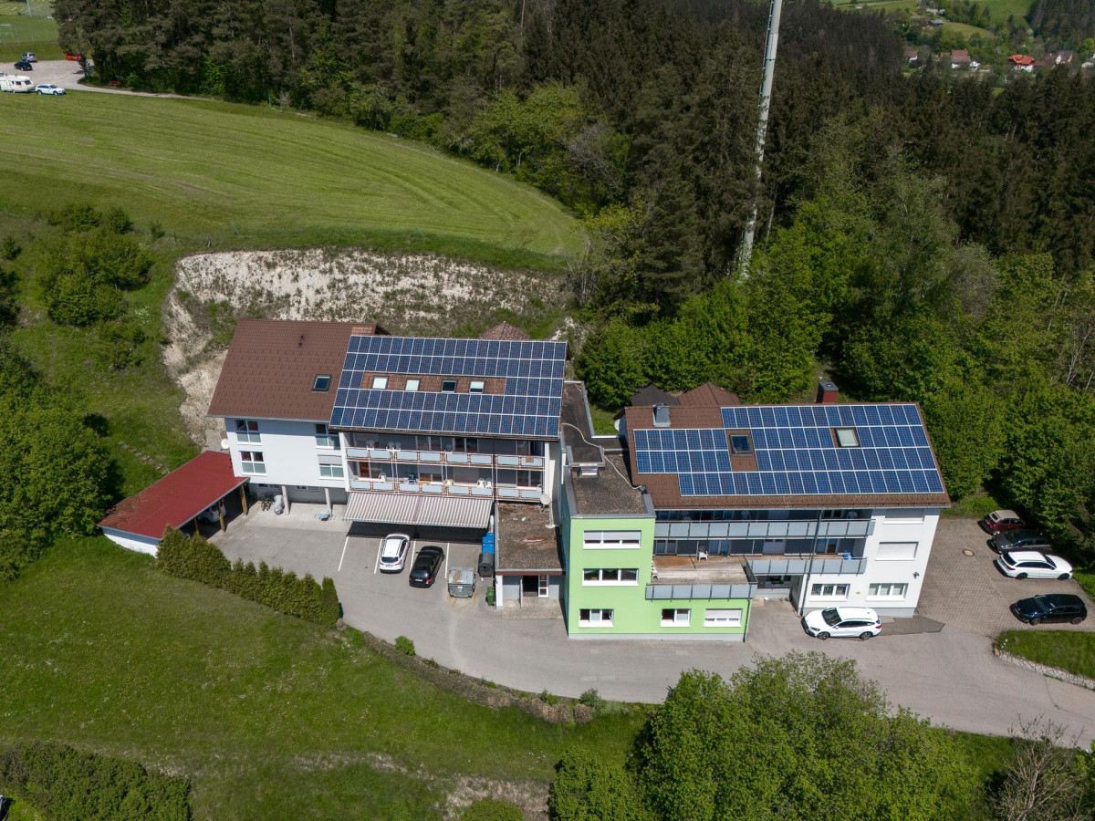 Luftaufnahme des Haus Berghof mit Solarpanelen.