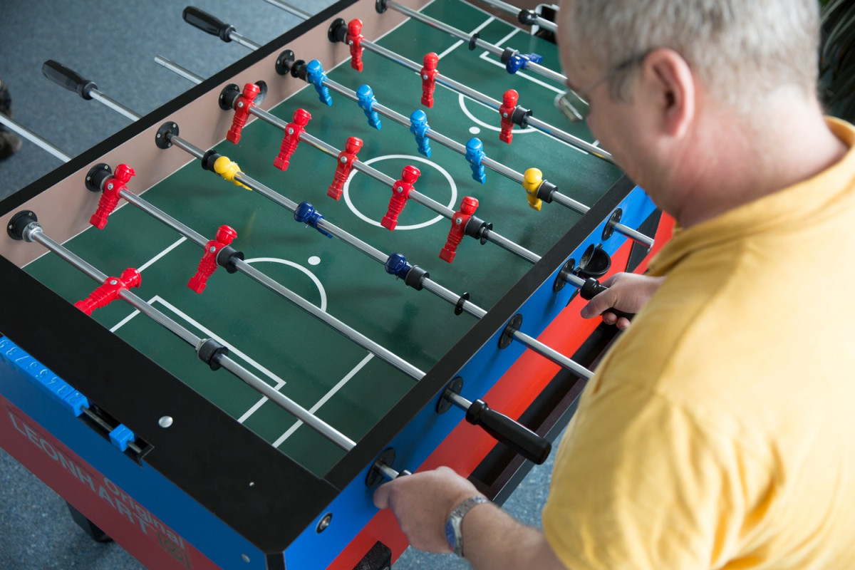 Person spielt Tischfu&szlig;ball.