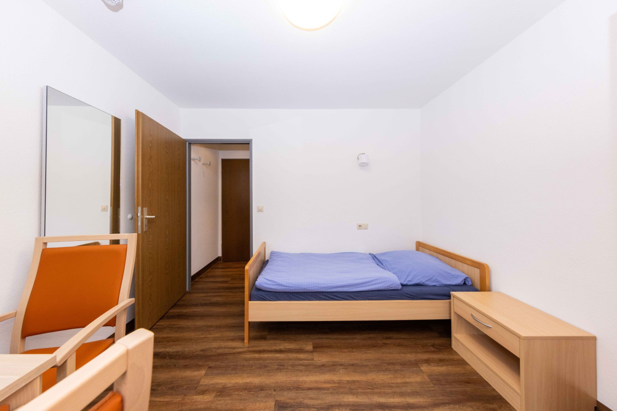 Helles Schlafzimmer mit Einzelbett und Holzm&ouml;beln.