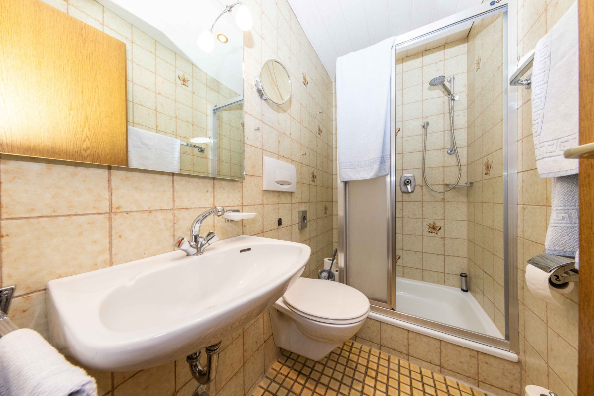 Badezimmer mit Waschbecken, Toilette und Dusche.