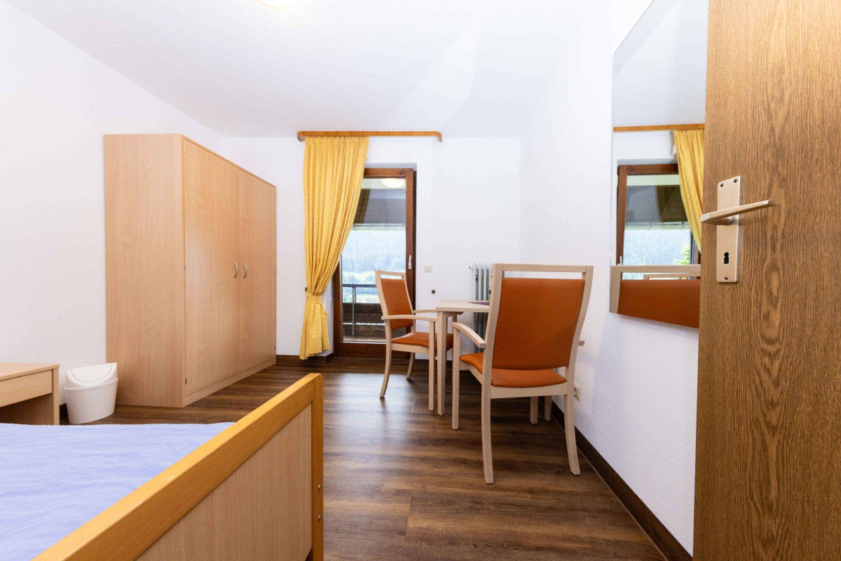 Helles Zimmer mit Holzm&ouml;beln und zwei Betten.