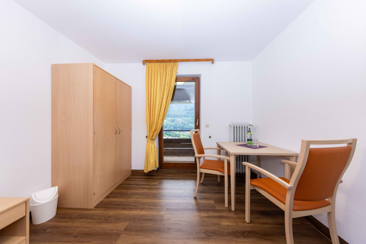 Helles Hotelzimmer mit Holzm&ouml;beln und Bergblick.