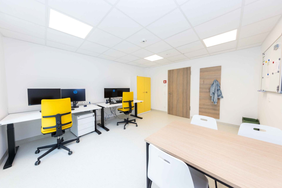 Modernes B&uuml;ro mit gelben St&uuml;hlen und Schreibtischen.