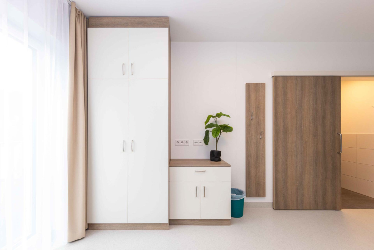Moderner Flurbereich mit wei&szlig;em Kleiderschrank und Holzt&uuml;ren.
