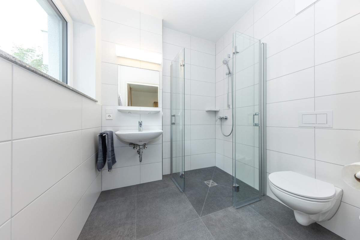 Modernes Badezimmer mit Dusche und Toilette.