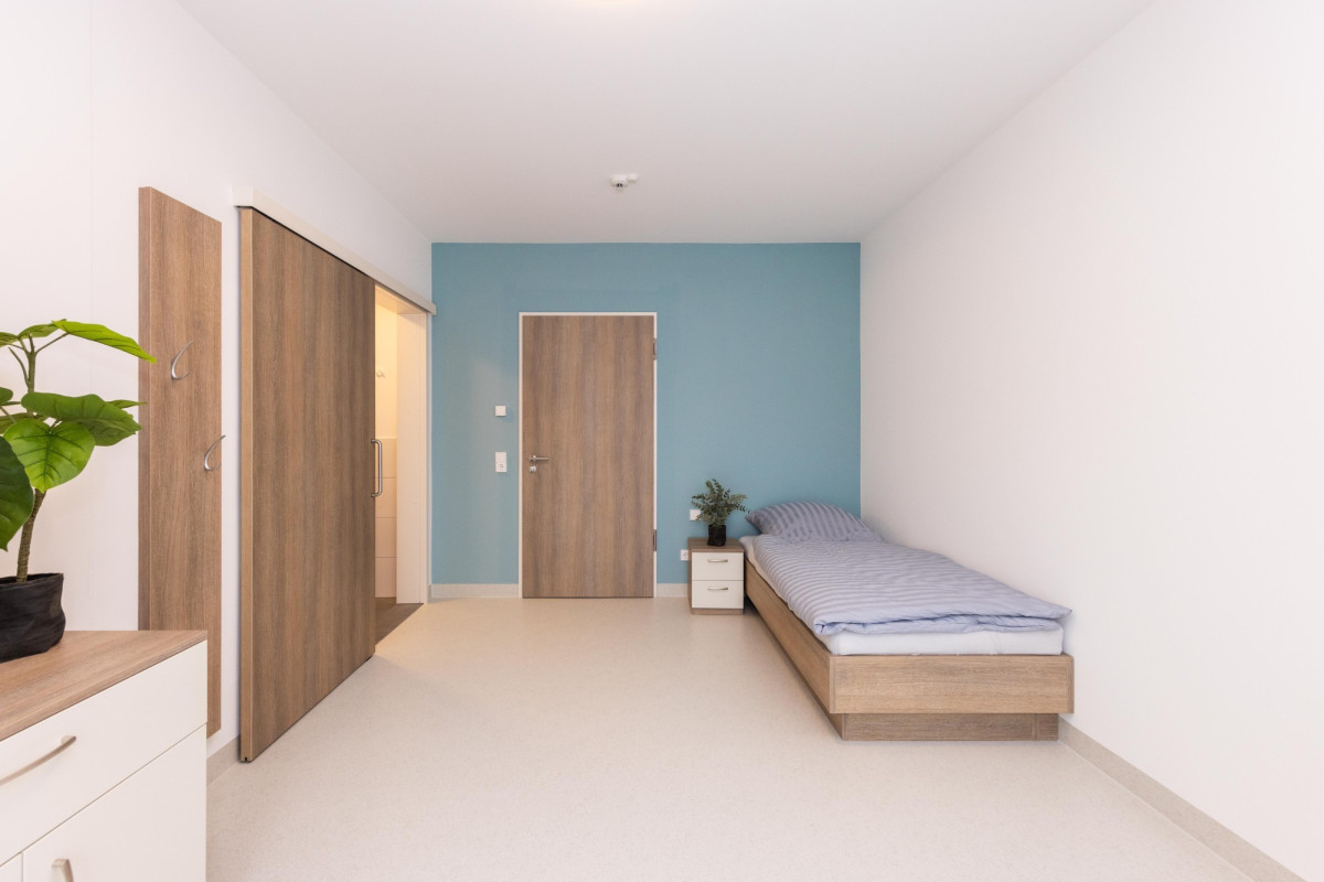 Schlafzimmer mit Holzbett und blauer Wand.