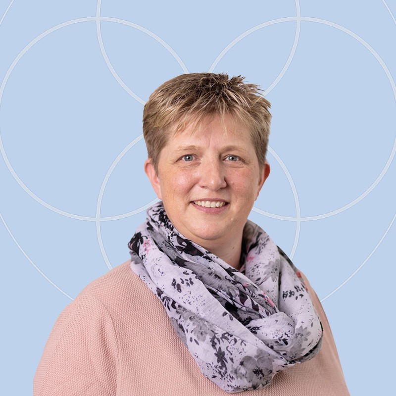Portr&auml;t einer l&auml;chelnden Frau mit kurzem blondem Haar.