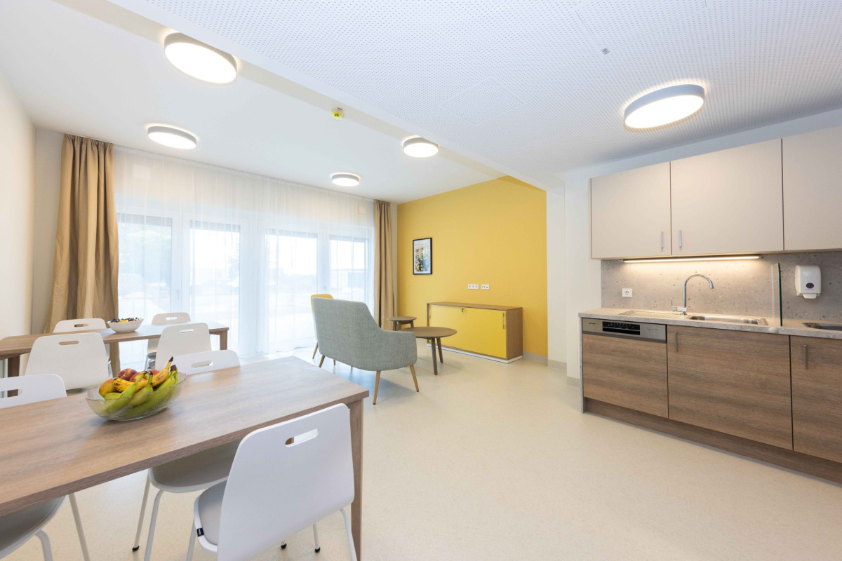 Modernes Wohnzimmer mit K&uuml;che und Essbereich.