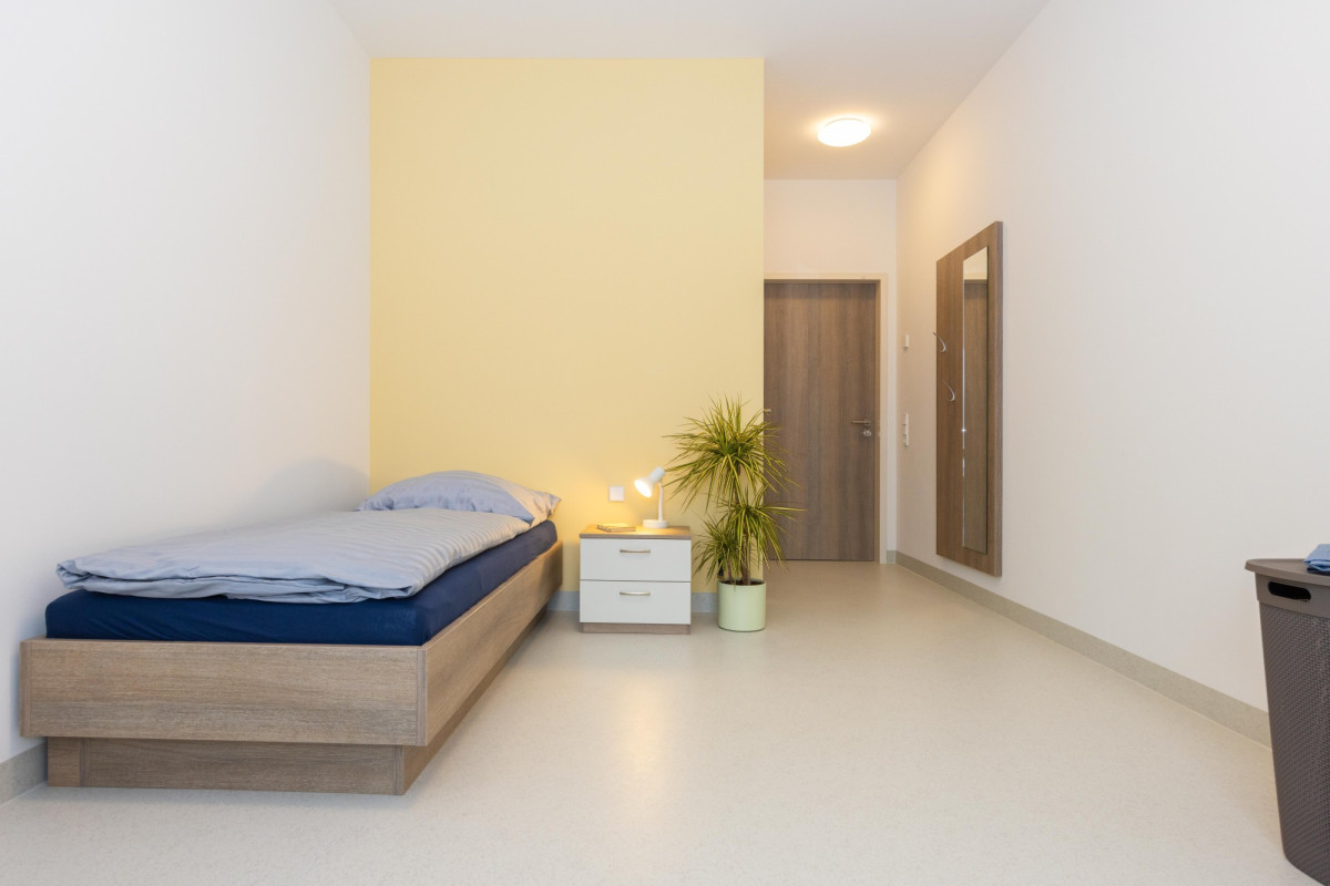 Modernes Schlafzimmer mit Einzelbett und heller Einrichtung.