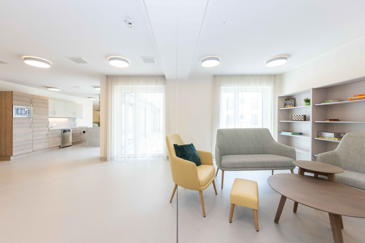 Modernes, helles Wohnzimmer mit Sitzm&ouml;beln und Regalen.