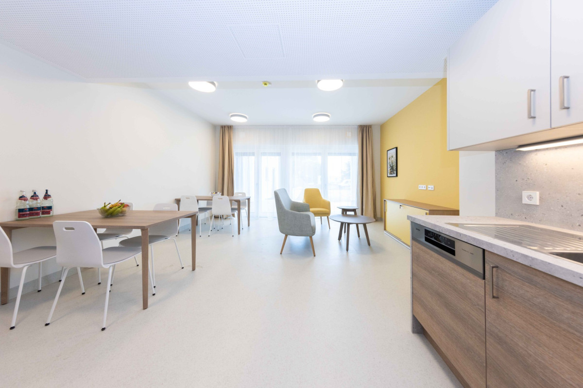 Helles Apartment mit K&uuml;che, Esstisch und Wohnbereich.