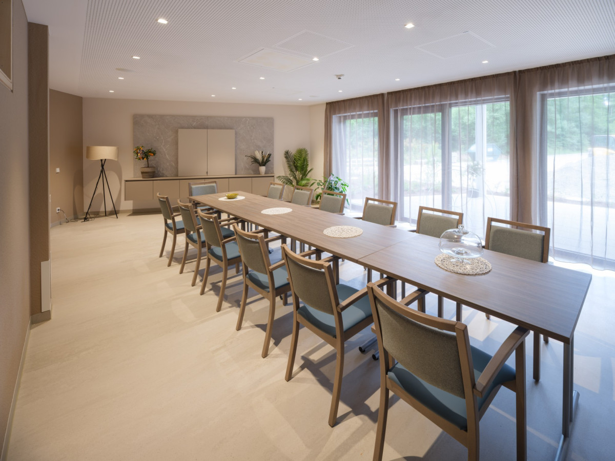 Moderner Speiseraum mit langer Holztafel und St&uuml;hlen.