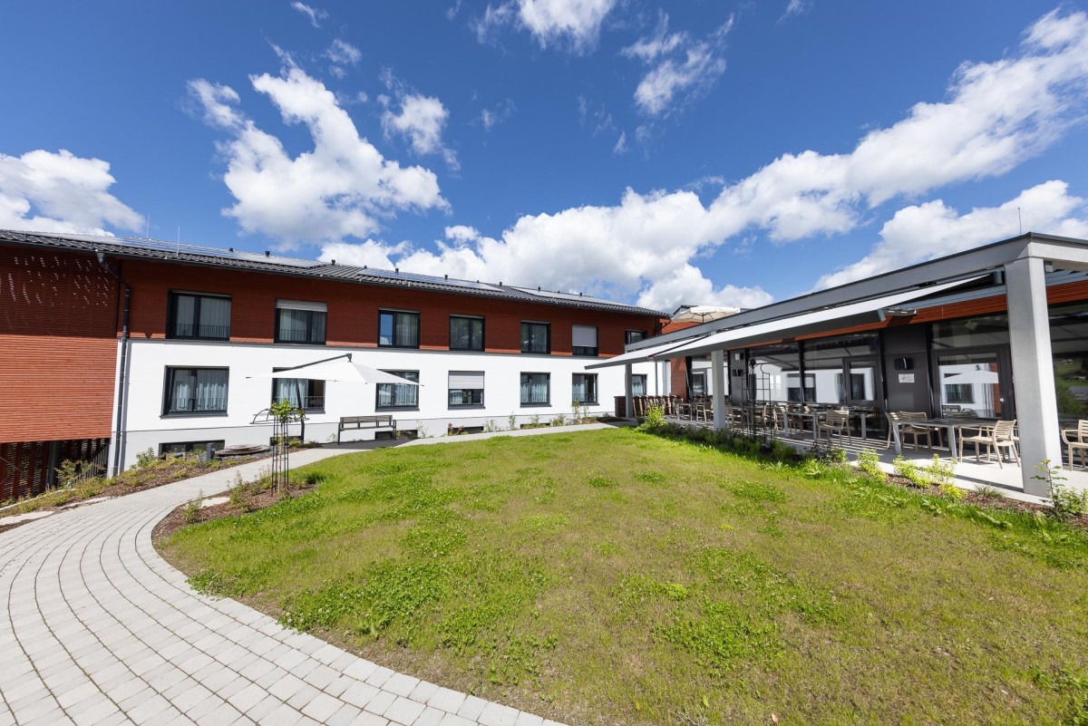 Modernes Seniorenzentrum mit Innenhof und Gr&uuml;nfl&auml;che.