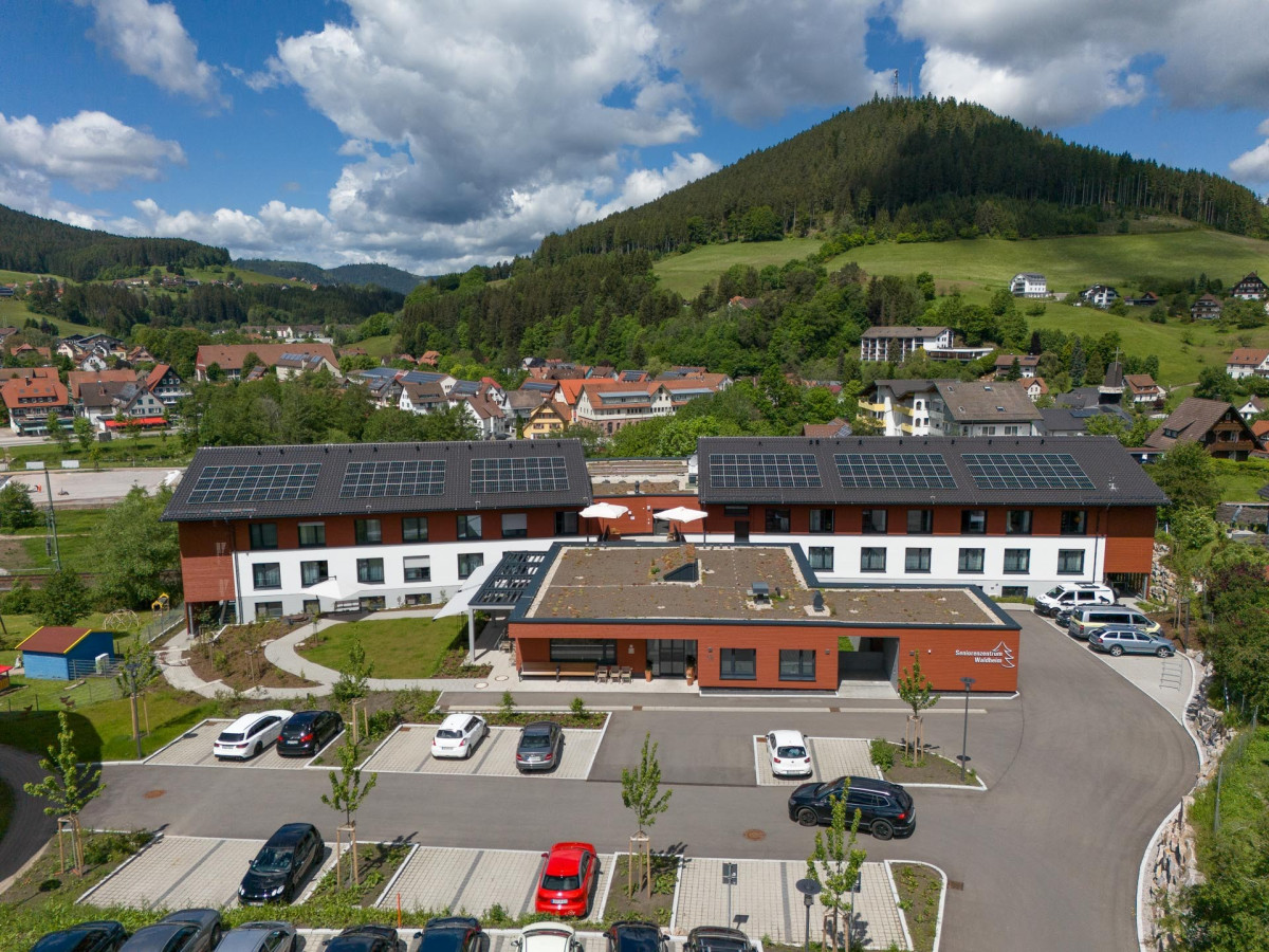 Seniorenzentrum Waldheim mit Parkplatz und Bergen.