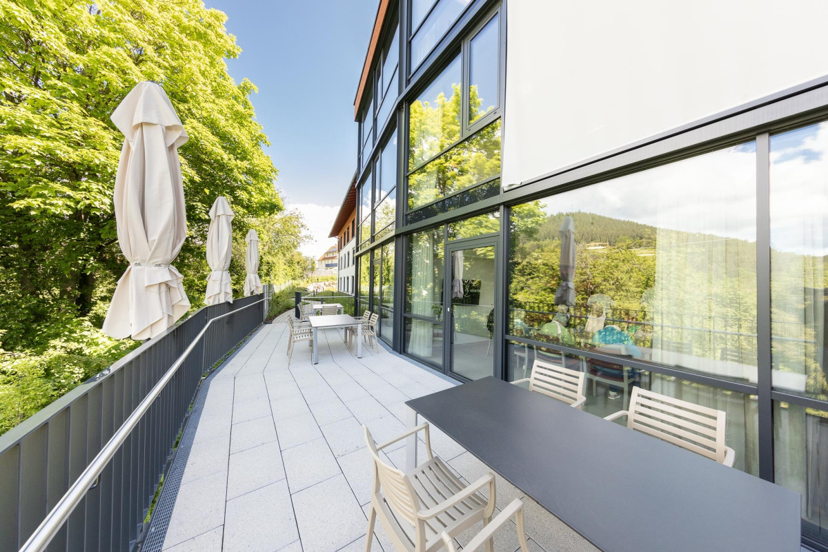Moderne Terrasse mit Sitzpl&auml;tzen und Gr&uuml;nfl&auml;chen.