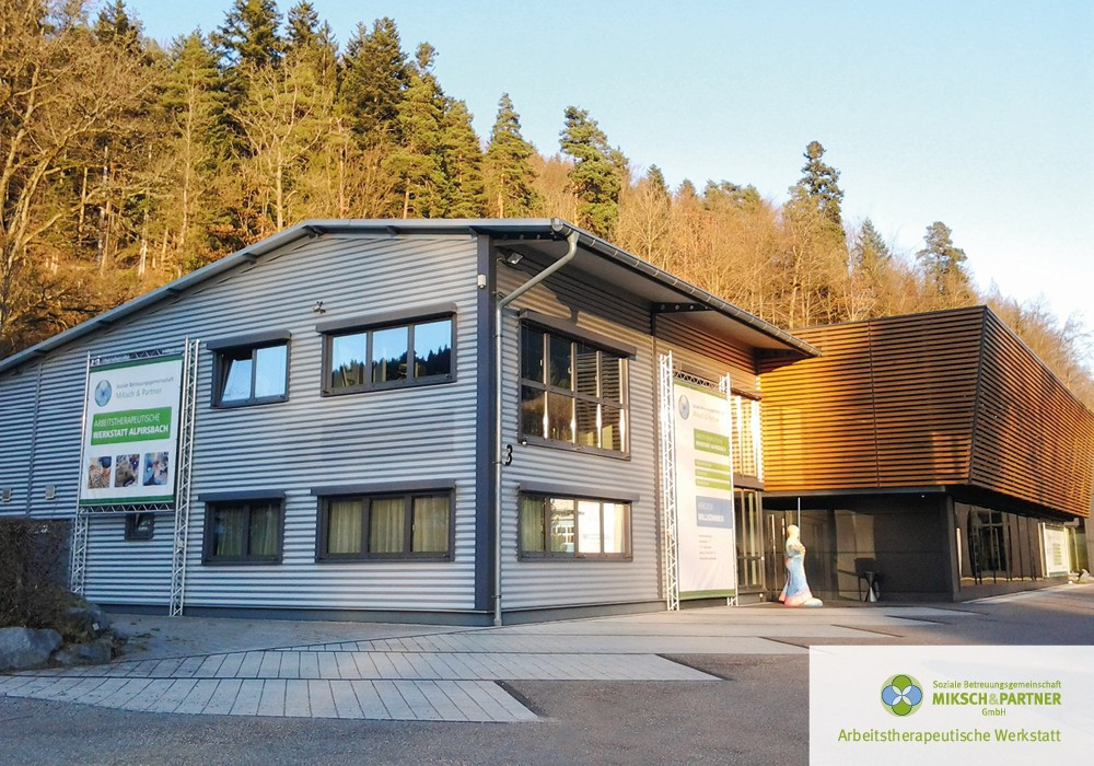 Modernes Werkstattgeb&auml;ude mit Holzfassade im Wald.