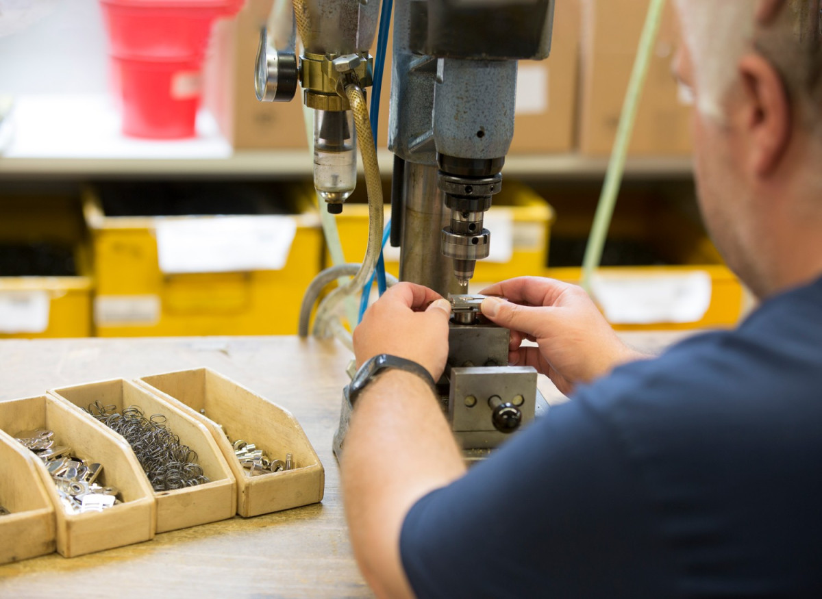 Handwerkerin arbeitet an einer Bohrmaschine.